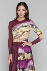 Woman wearing a long-sleeve dress with abstract pattern on a plain background