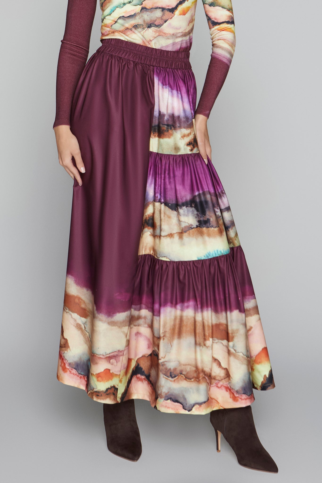 Long dress with a colorful abstract pattern and maroon skirt on a gray background