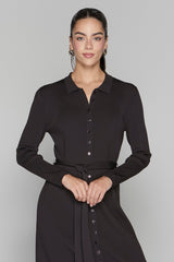 Woman wearing a black dress against a gray background