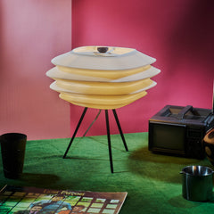 Modern lamp with a pink wall and vintage television in the background