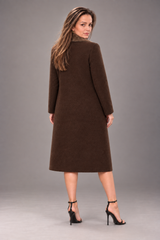 A woman modeling a long-sleeved, knee-length brown coat from the back, standing against a solid gray studio background.