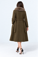 A woman viewed from the back wearing an olive green belted coat with a brown fur collar, paired with black high-heeled sandals, against a light gray studio background.