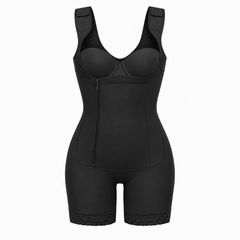 Black shapewear bodysuit with shoulder straps, molded cups, a front zipper, and fitted shorts with lace trim at the hem, shown on a plain light gray background.