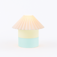 Pastel-colored lamp with a pleated shade on a white background