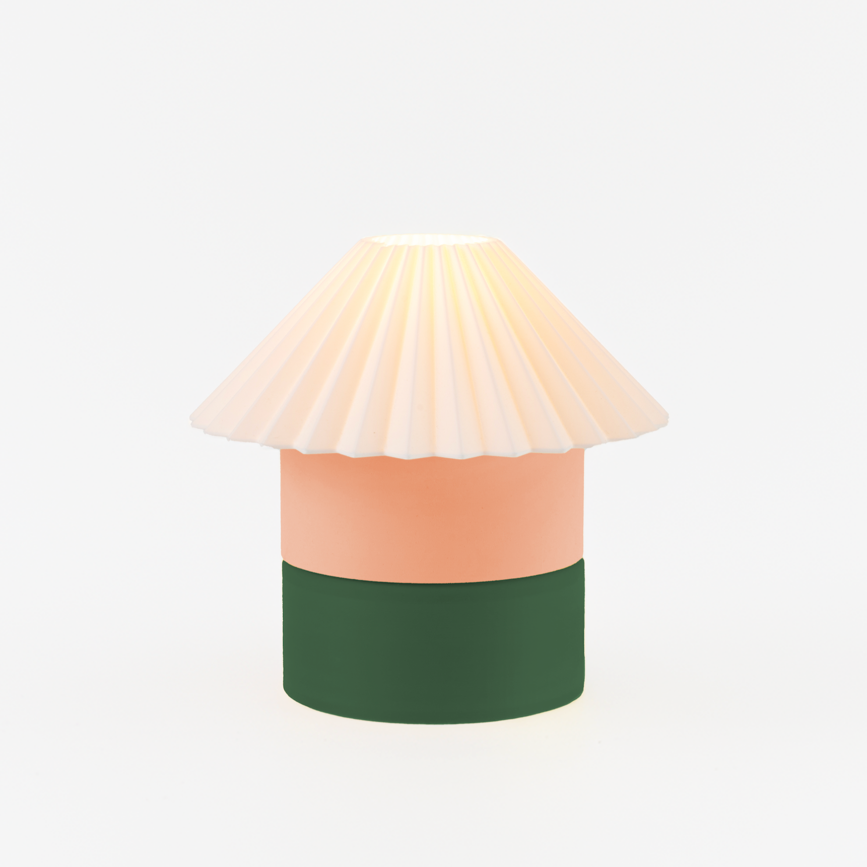 Decorative lamp with a white shade, peach body, and green base on a light beige background