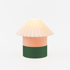 Decorative lamp with a white shade, peach body, and green base on a light beige background