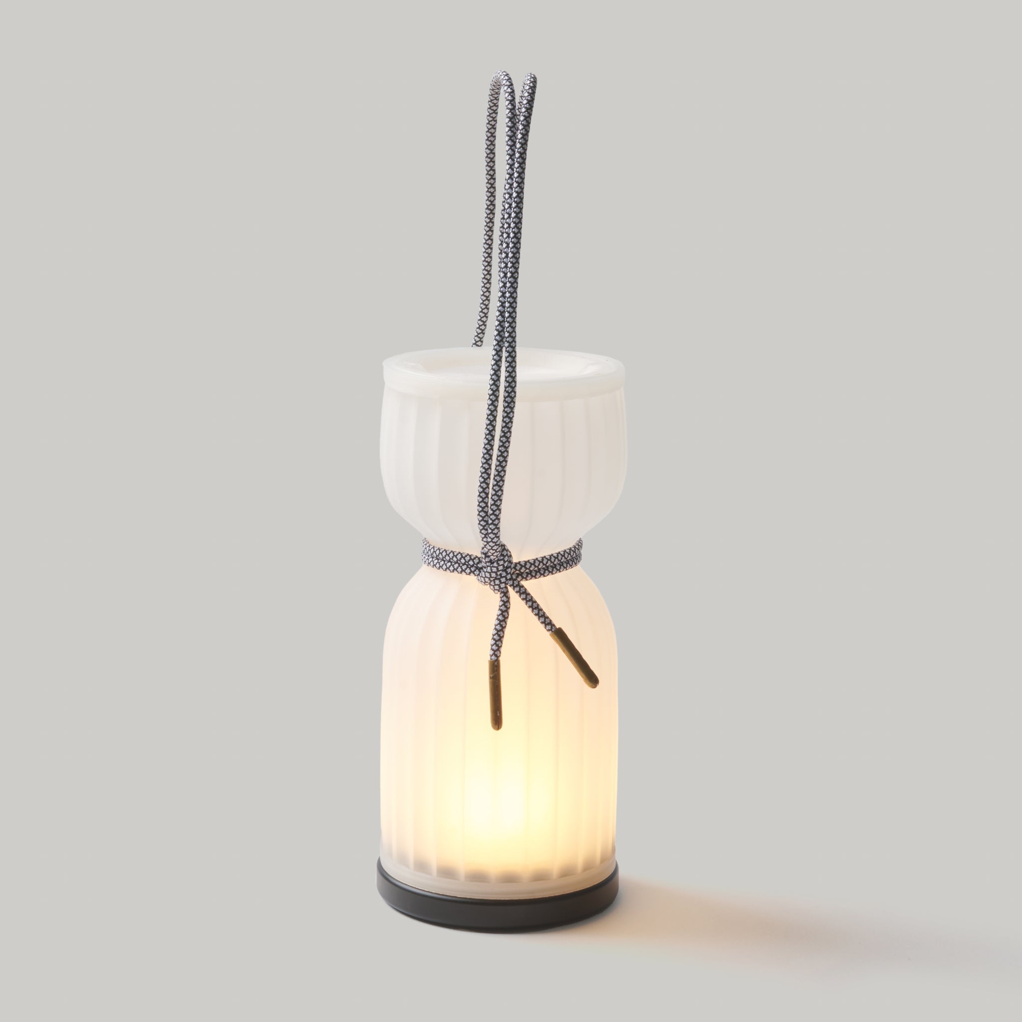 Ceramic lantern with a light inside on a gray background