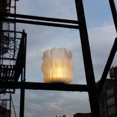 Decorative lamp with wavy design against a city skyline