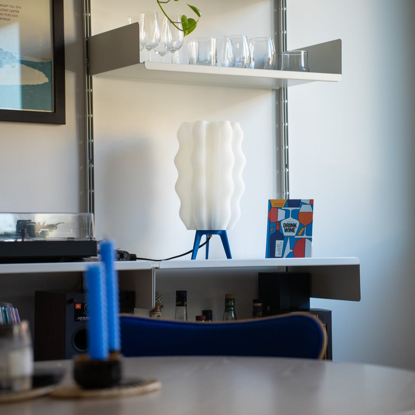 Modern interior with a shelf, lamp, and colorful box on a white surface.