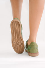 Green casual shoes with brown soles on a white background