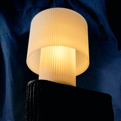 Lamp with pleated shade on a dark blue background