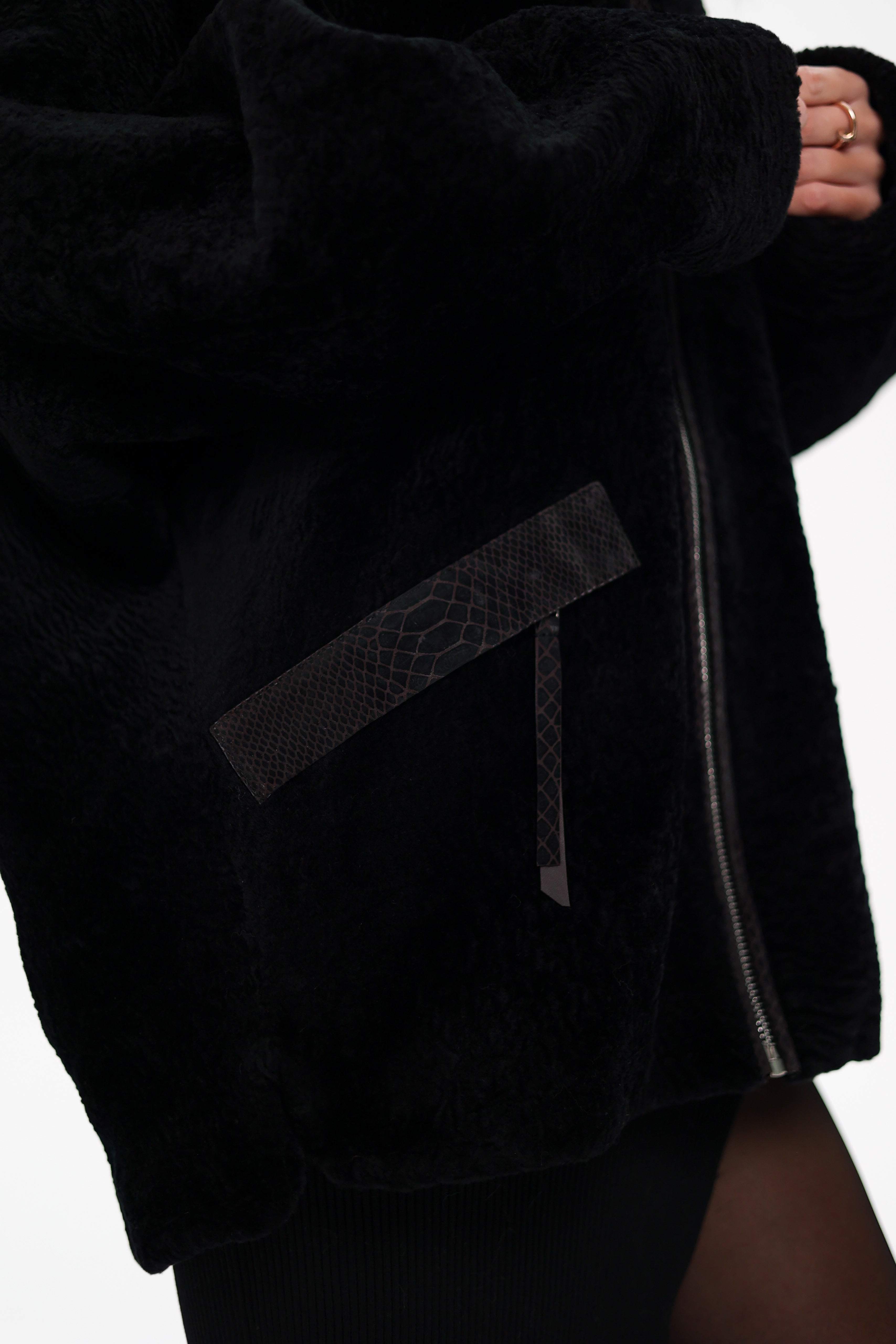 Woman wearing a black coat with fur collar on a white background