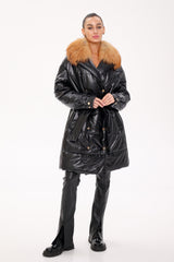 Person wearing a black coat with fur collar on a white background