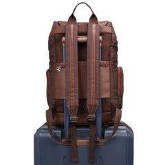 Brown backpack on a blue suitcase against a white background