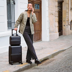 Woman with two black suitcases on a city street