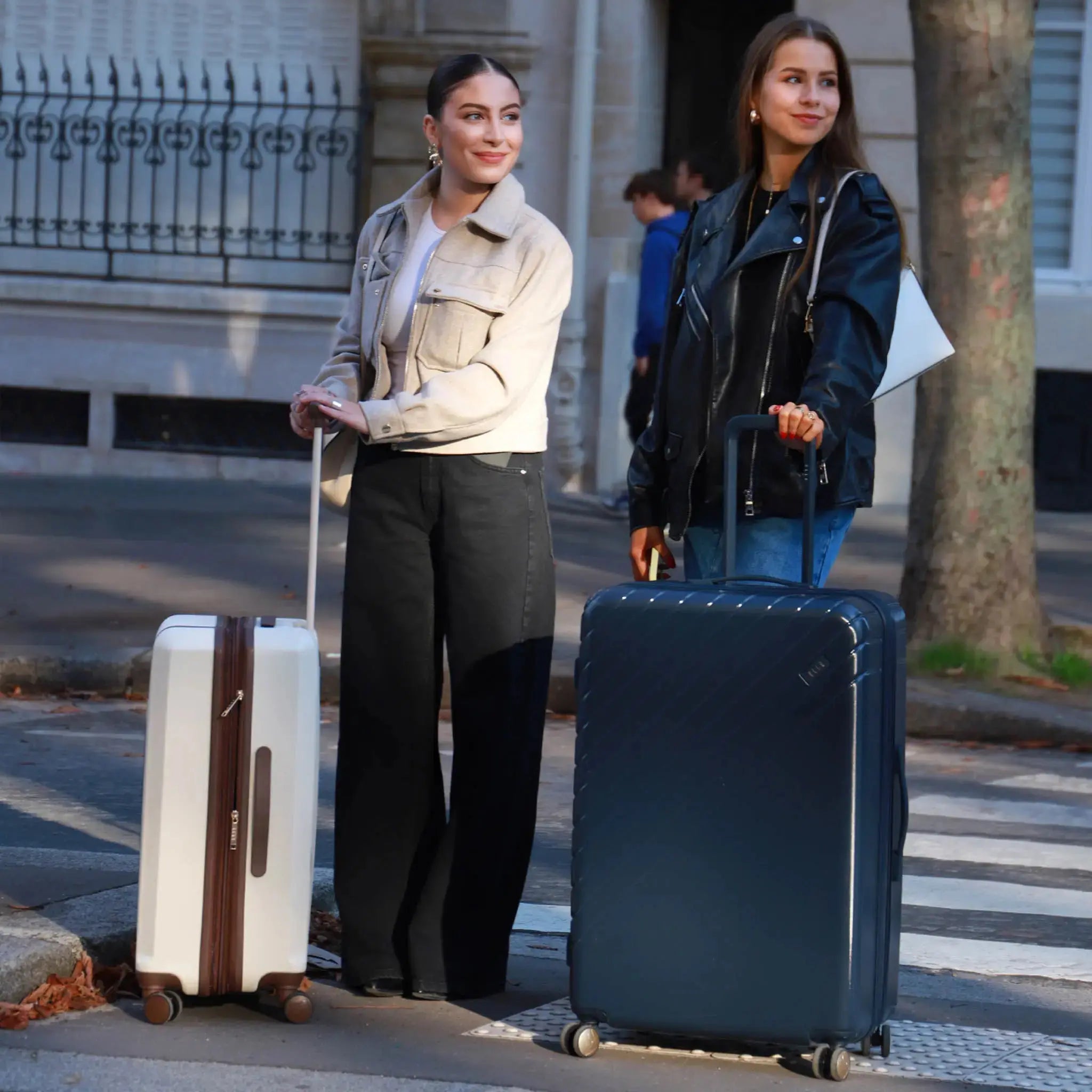 Two women with suitcases on a city street