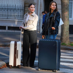 Two women with suitcases on a city street