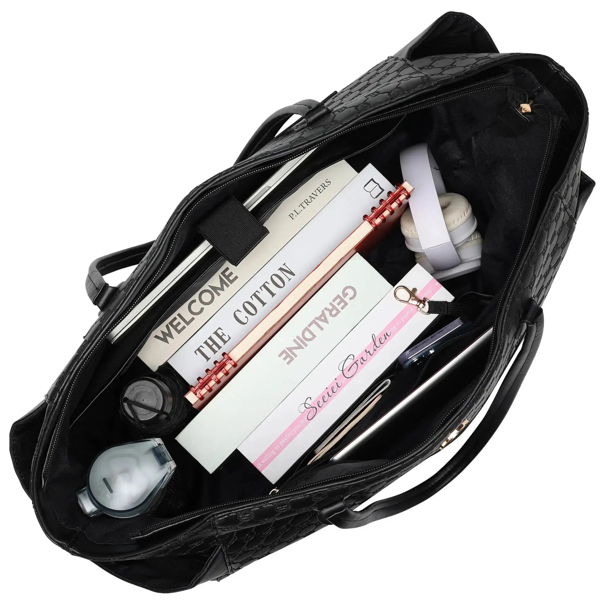 Black handbag with stationery items including books and a pen on a white background