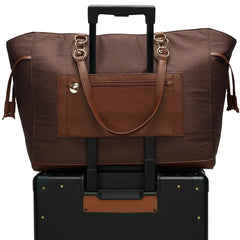 Brown travel bag with handle and wheels on top of a black suitcase.