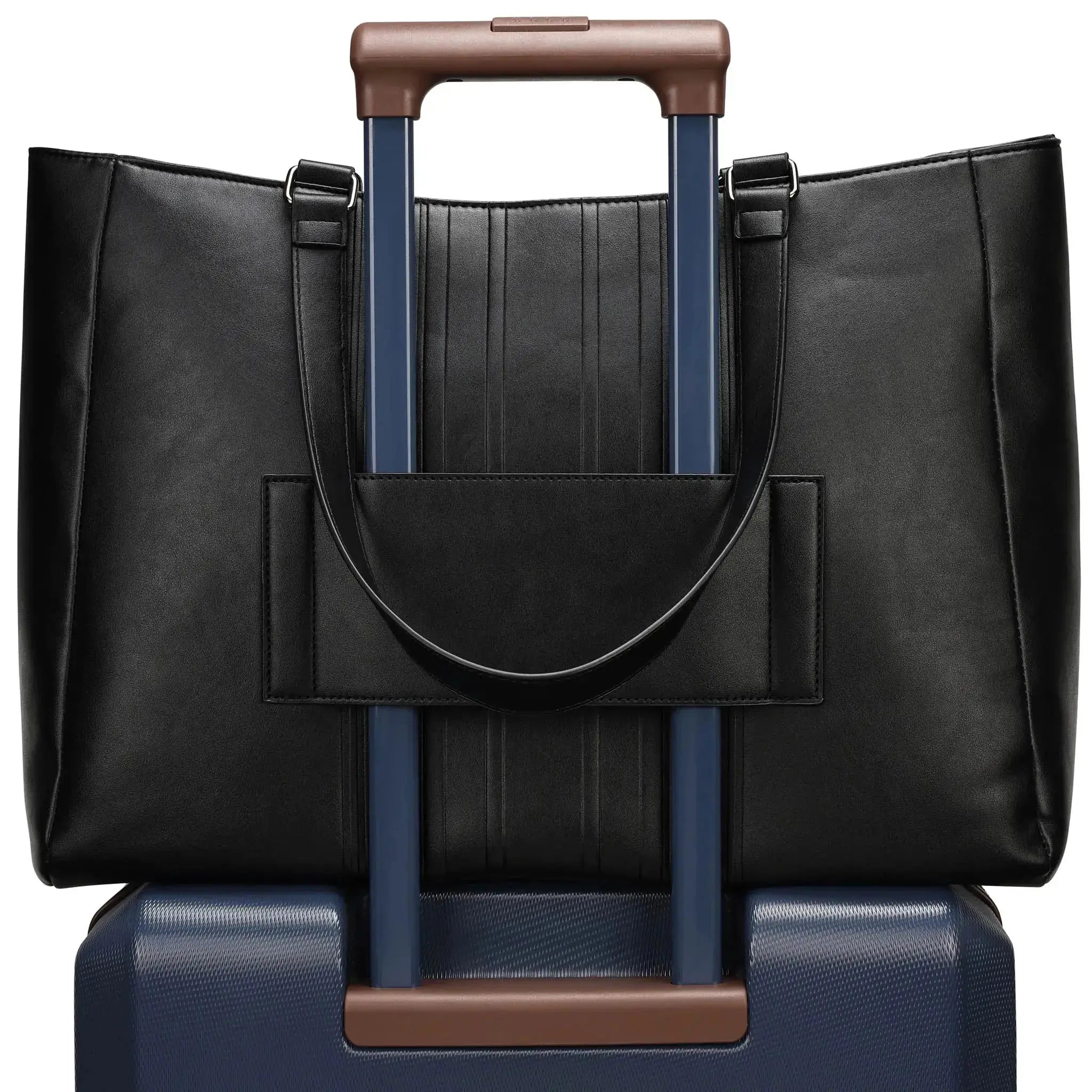 Black leather tote bag with brown handle on top of a blue suitcase with brown handle