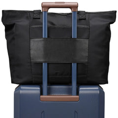 Black bag with blue handle on top of a blue suitcase
