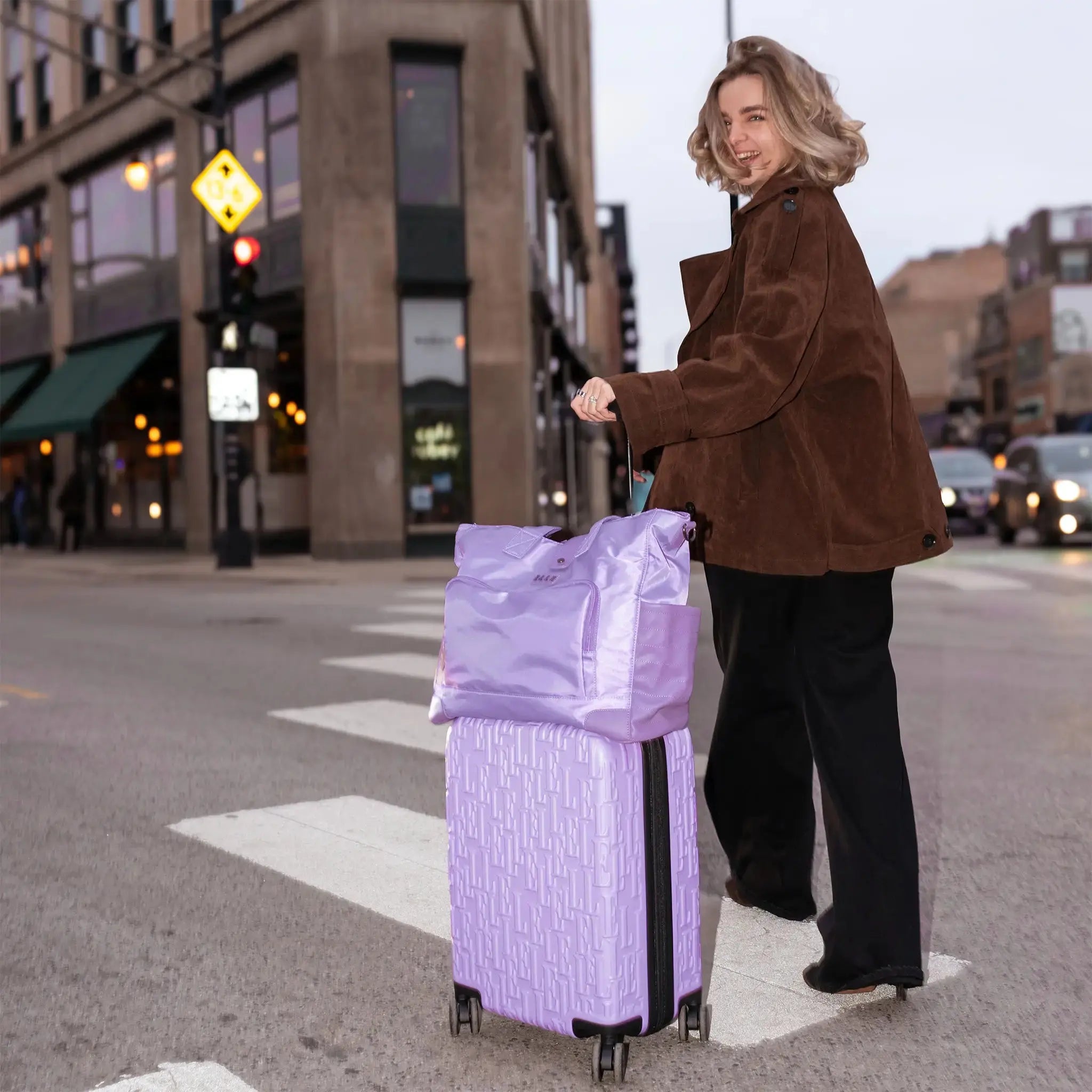 Woman pulling a purple suitcase on a city street