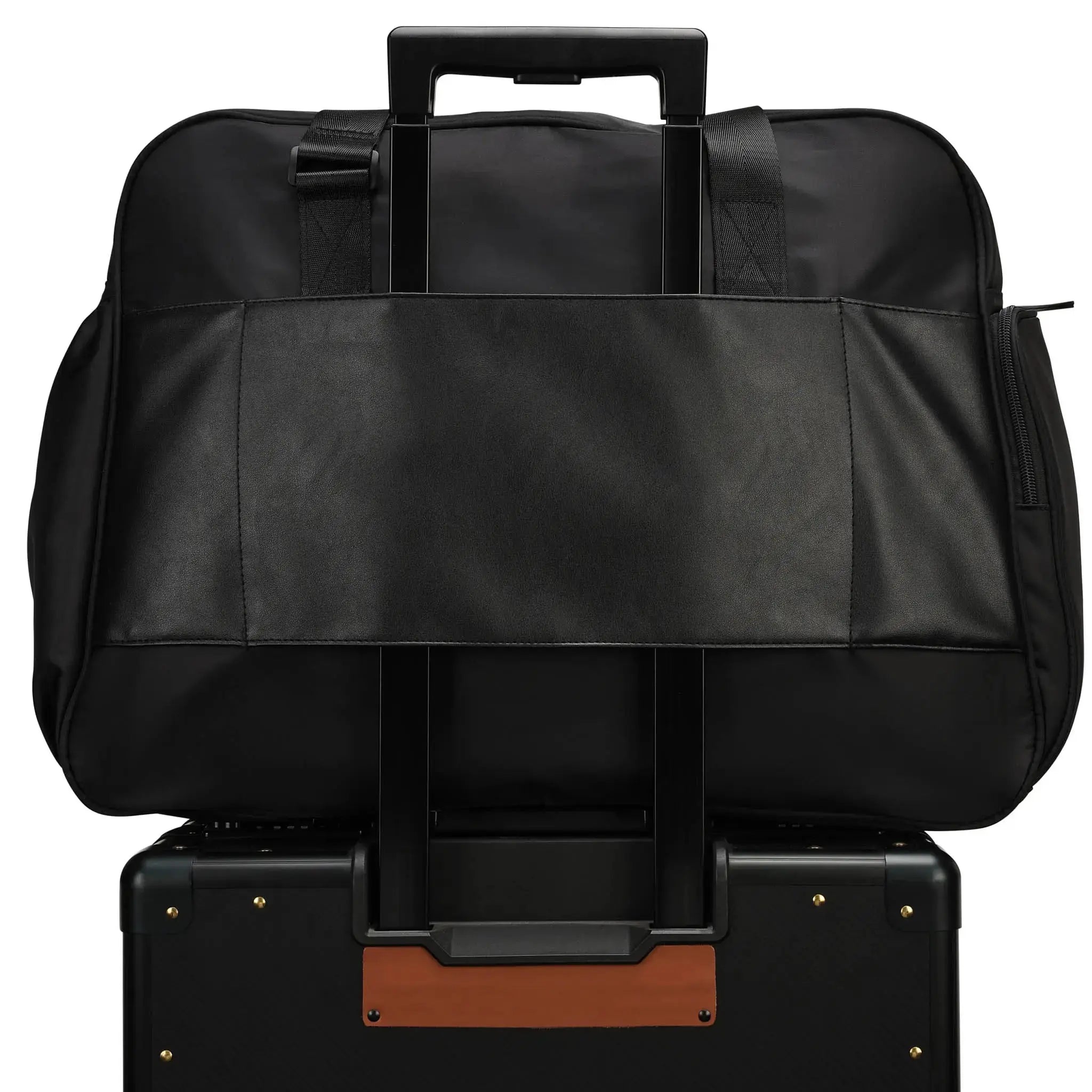 Black travel bag on top of a black suitcase with brown accents