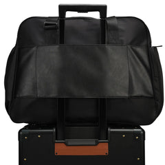 Black travel bag on top of a black suitcase with brown accents