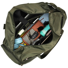 Green bag with various items including a phone and wallet on a white background