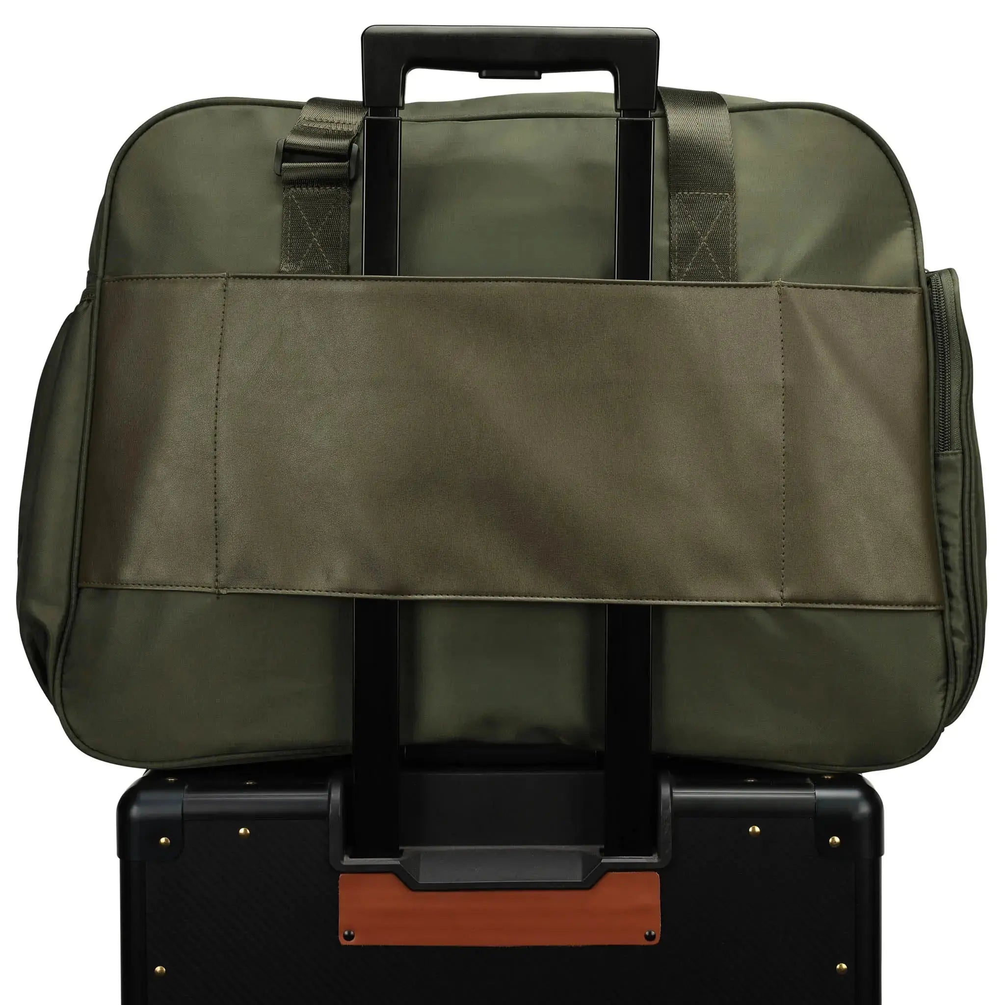 Green duffel bag on top of a black suitcase with a white background