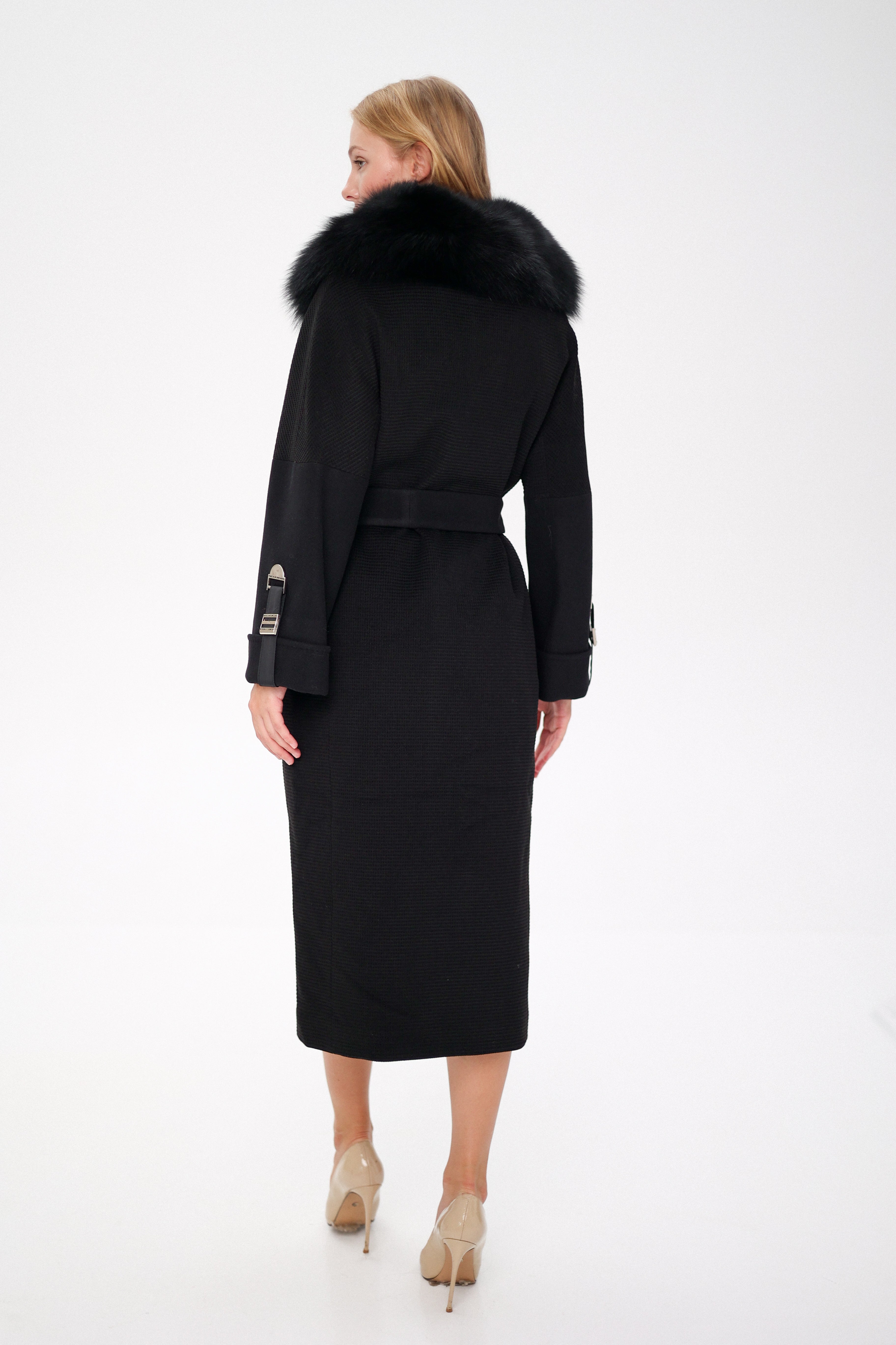 Woman wearing a black coat with fur collar on a white background