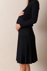 Person wearing a black dress against a beige background