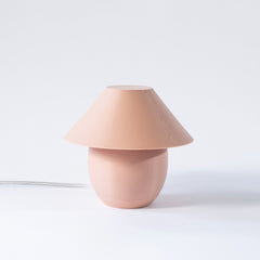 Pink table lamp with a unique design on a white background