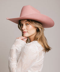 Woman wearing a pink hat against a plain background