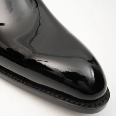 Close-up of a glossy black shoe on a white background