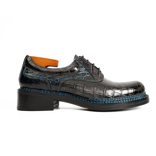 Black crocodile-patterned shoe with blue sole on a white background