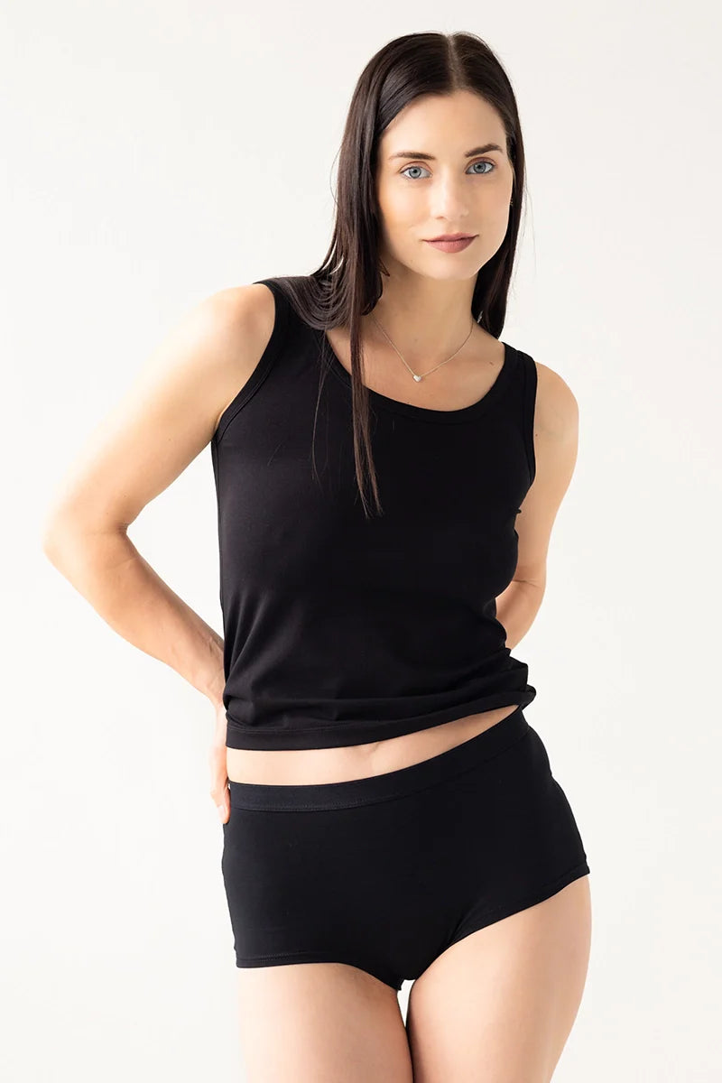 Woman wearing a black sleeveless top and black shorts on a white background
