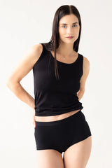 Woman wearing a black sleeveless top and black shorts on a white background