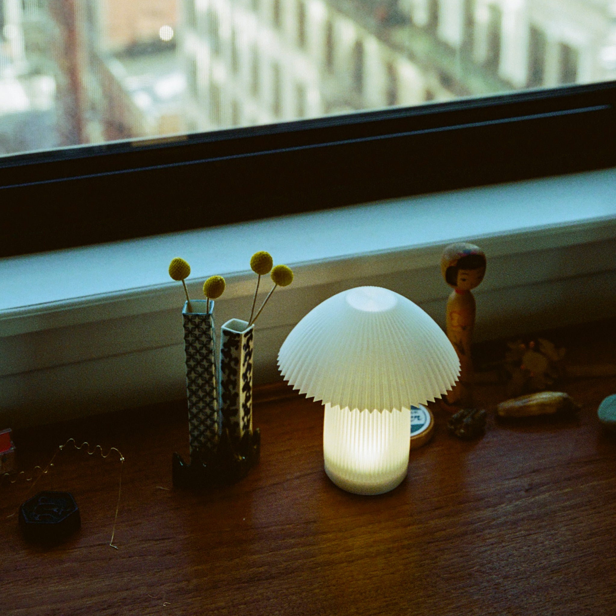 Mushroom-shaped lamp on a windowsill with decorative items
