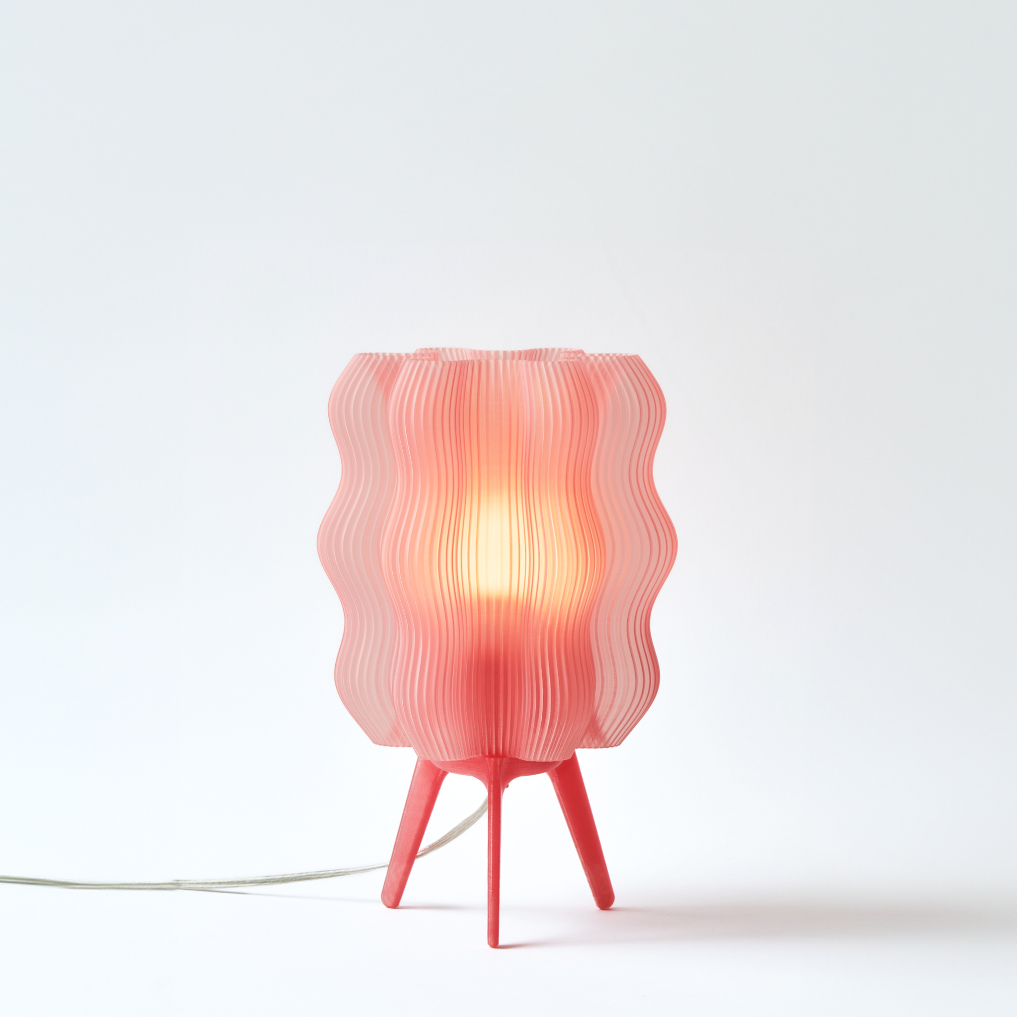 Pink table lamp with wavy design on a white background