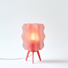 Pink table lamp with wavy design on a white background