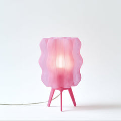 Pink table lamp with wavy design on a white background
