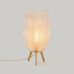 Table lamp with wavy lampshade on a light gray background