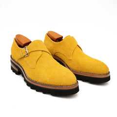 Pair of yellow shoes with brown soles on a white background