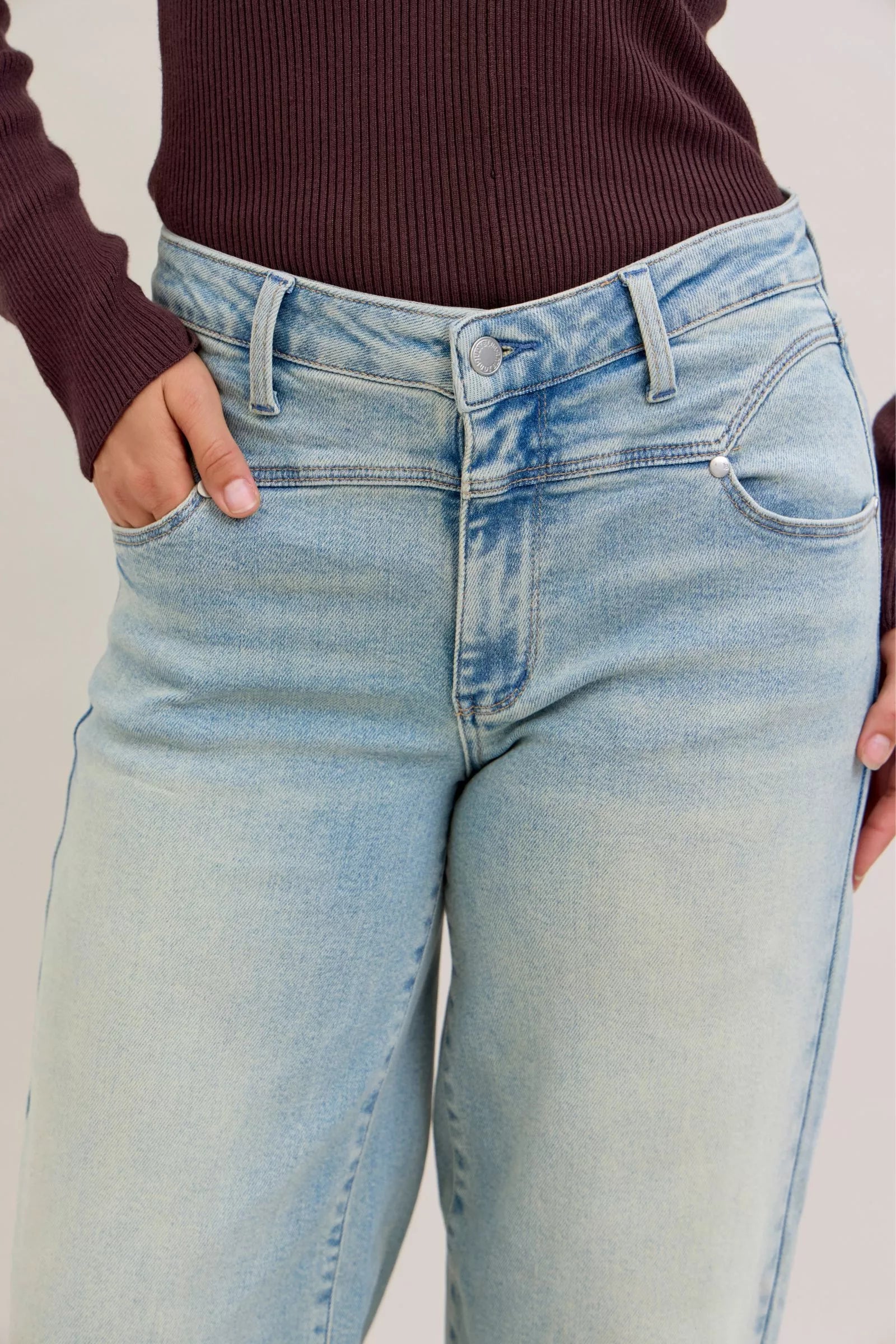 Light blue jeans worn by a person with a neutral background