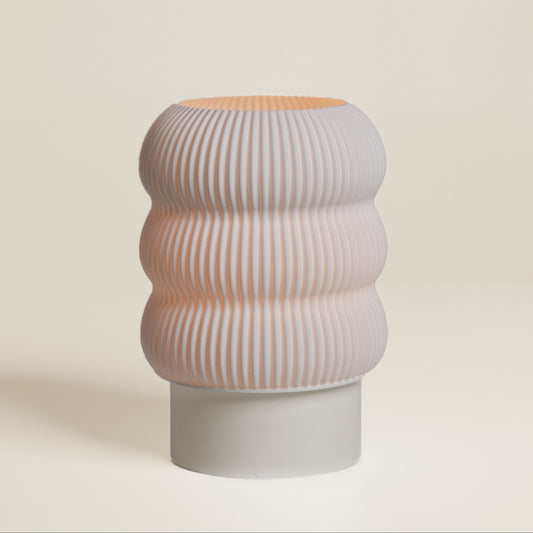 Cylindrical ceramic vase with ribbed texture on a beige background