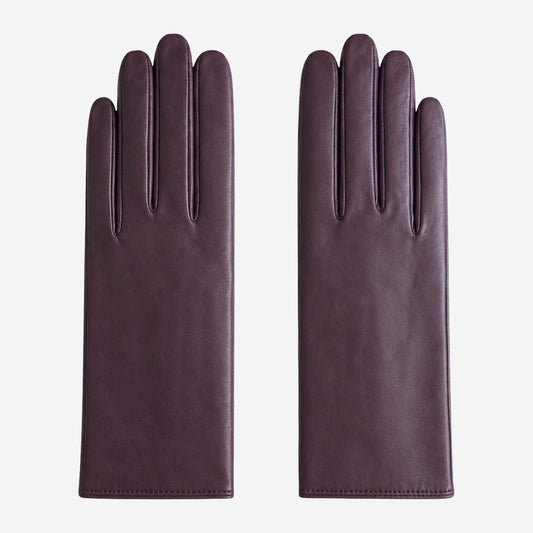 Pair of dark purple leather gloves on a white background