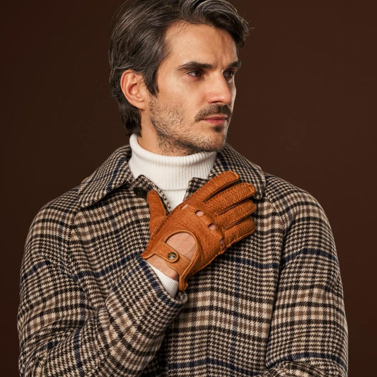 Man wearing a plaid coat and brown leather glove against a dark background