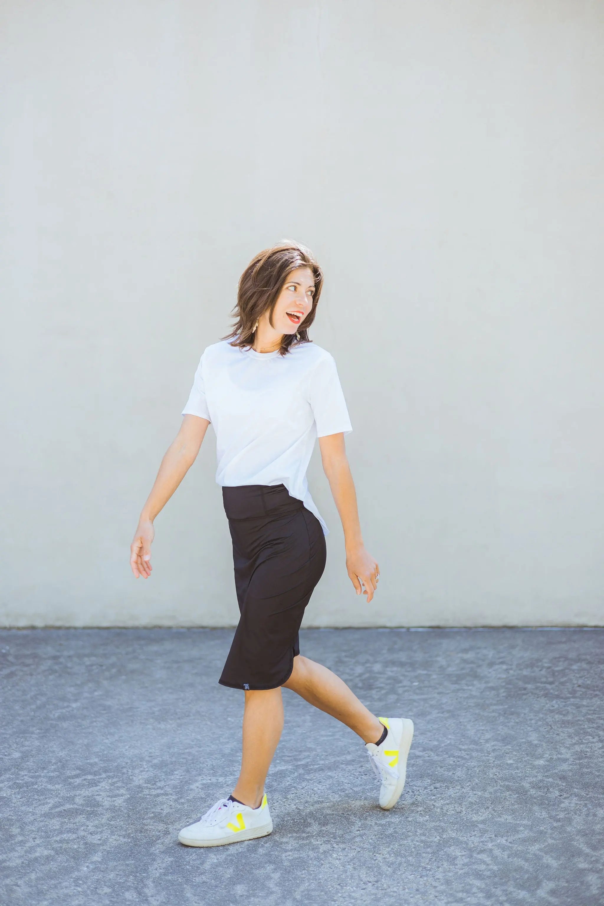 Woman walking on a gray surface with a plain background
