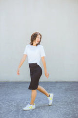 Woman walking on a gray surface with a plain background
